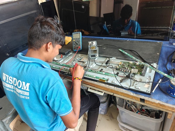 “Skilled technician repairing a LED TV at Wisdom Electronics & Computers, Pune