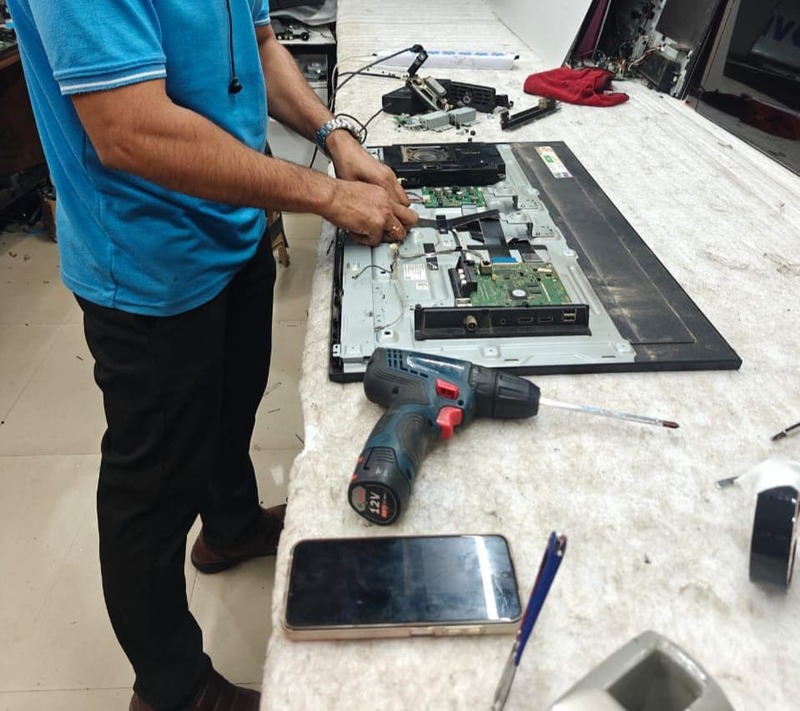 Technician repairing LED TV screen panel at Wisdom Electronics,Pune