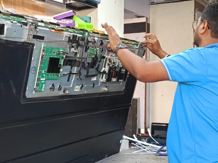 Samsung LED TV repair service with a professional technician fixing TV